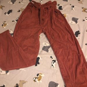 burnt orange pants with cinched waist and belt
